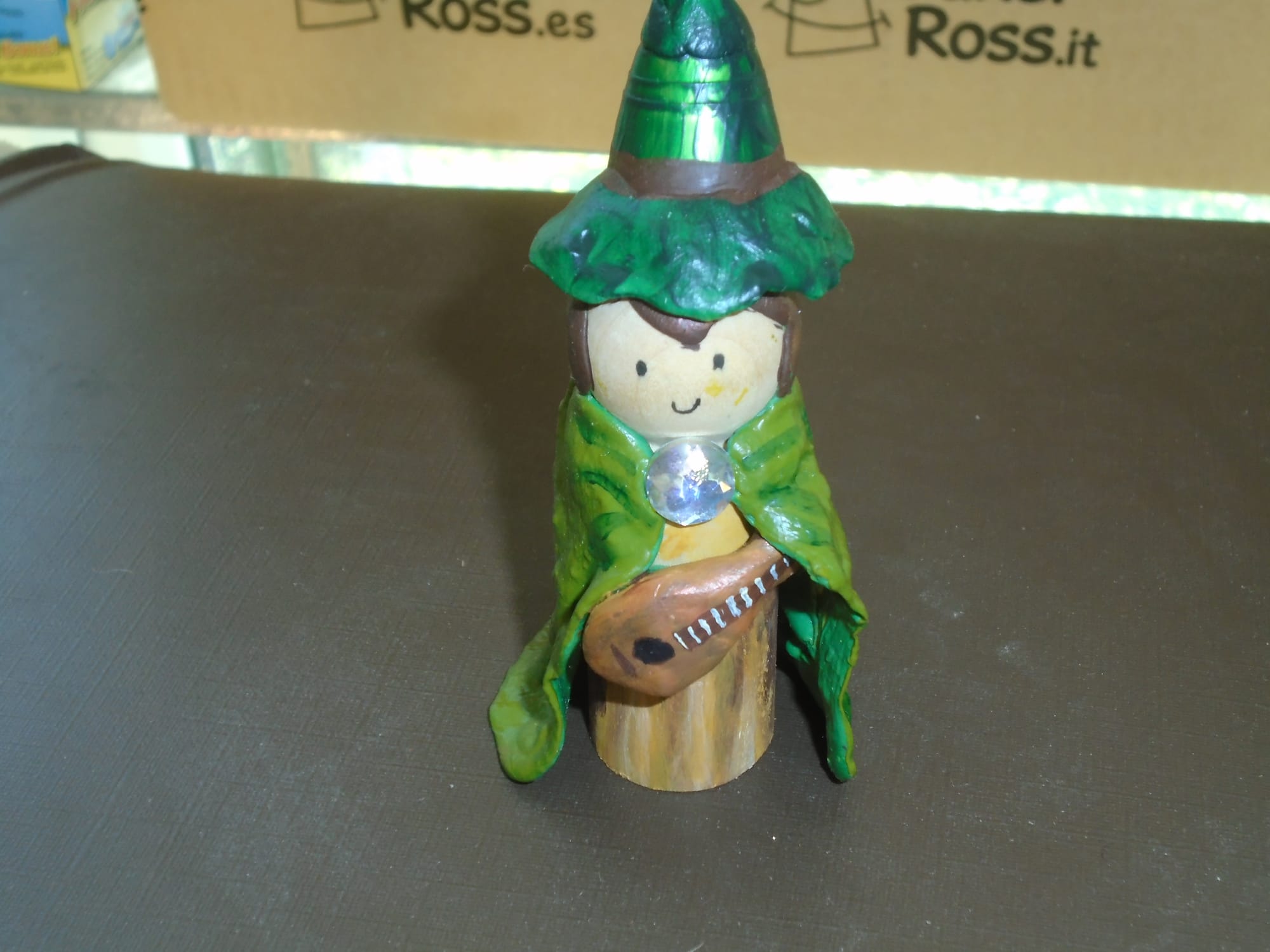 The same bard figure, now wearing a large green pointy hat with a floppy brim.