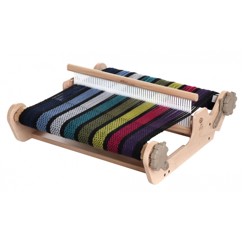 The heddle on this loom has a row of central holes alternating with long slots. The warps pass through alternately.