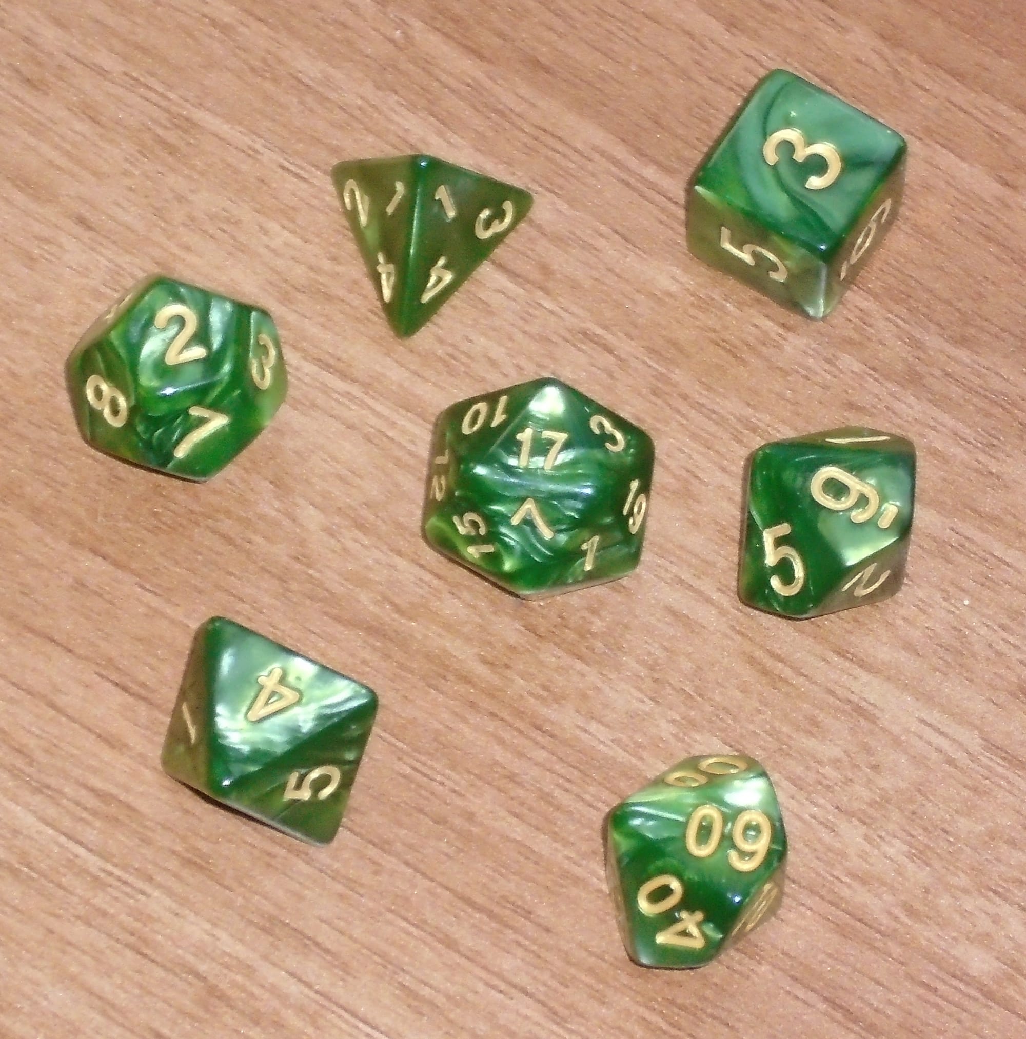 7-piece RPG dice set consisting of all five Platonic solids plus two ten-sided dice (0-9 and 00-90); green/gold.