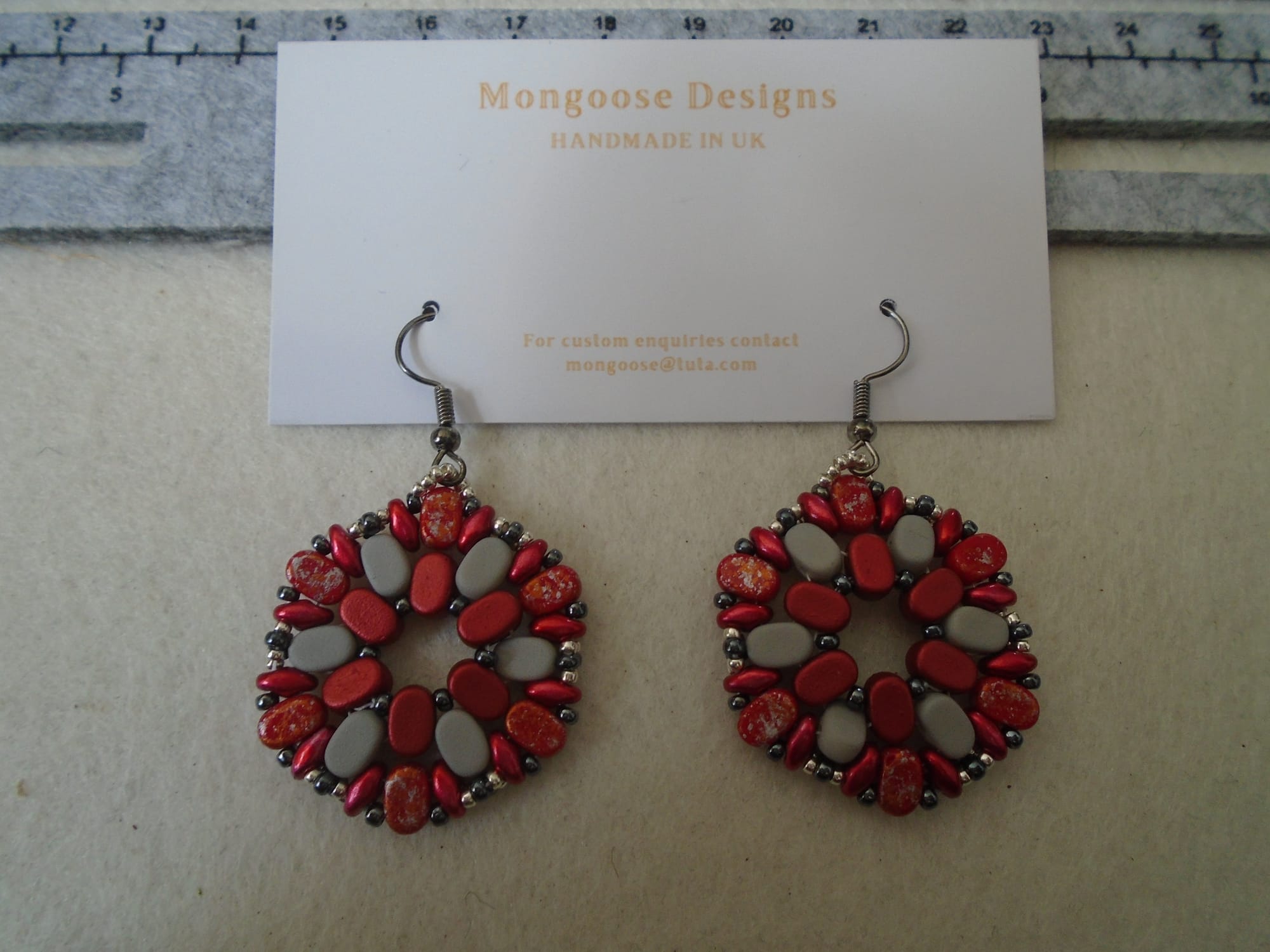 Inner Lipsis plain red; middle, light grey; outer, red splash; SuperDuos, red; haematite and silver seed beads.
