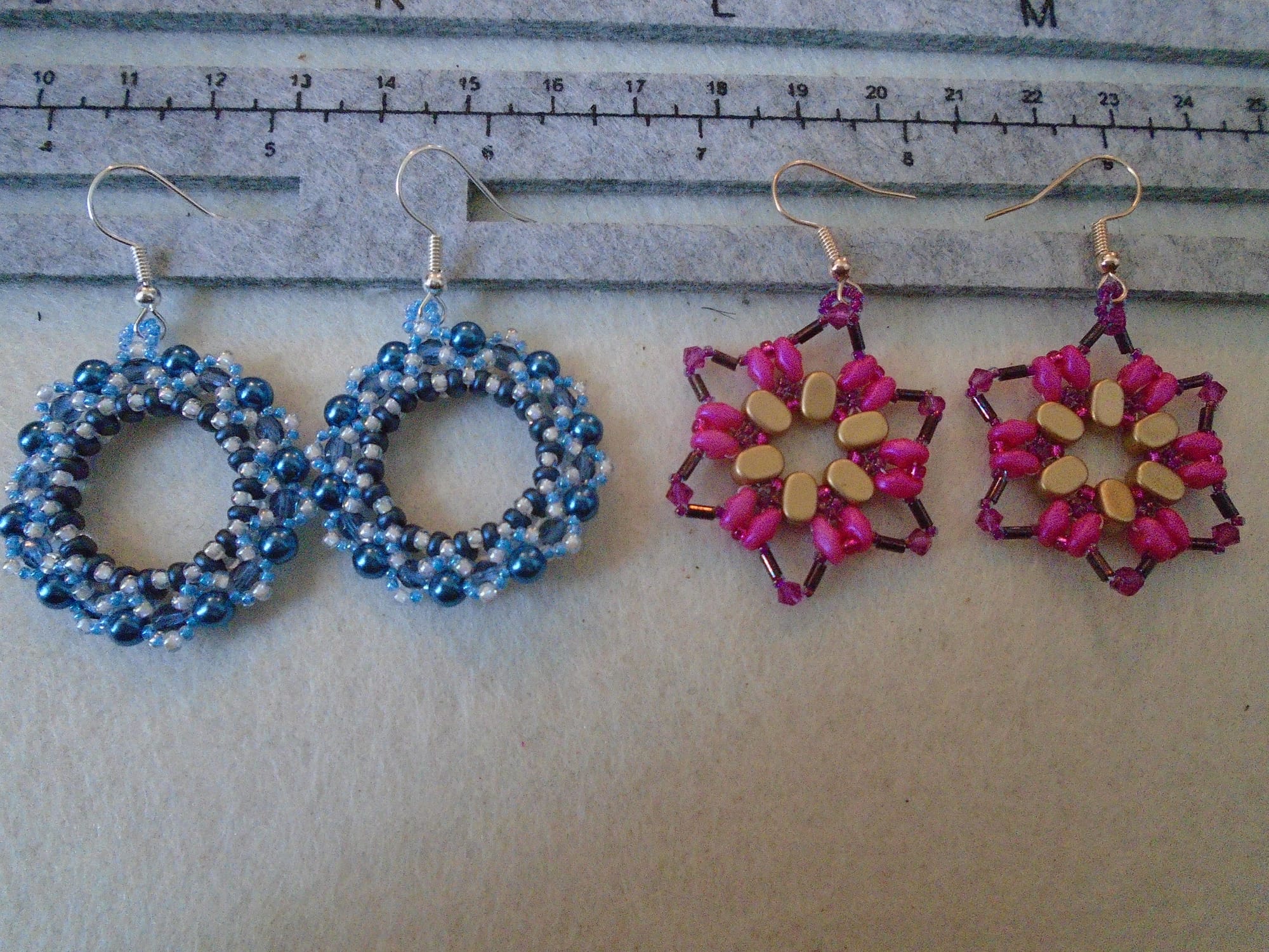 Blue and crystal wreath earrings; fuchsia pink, raspberry, and rose gold star earrings.