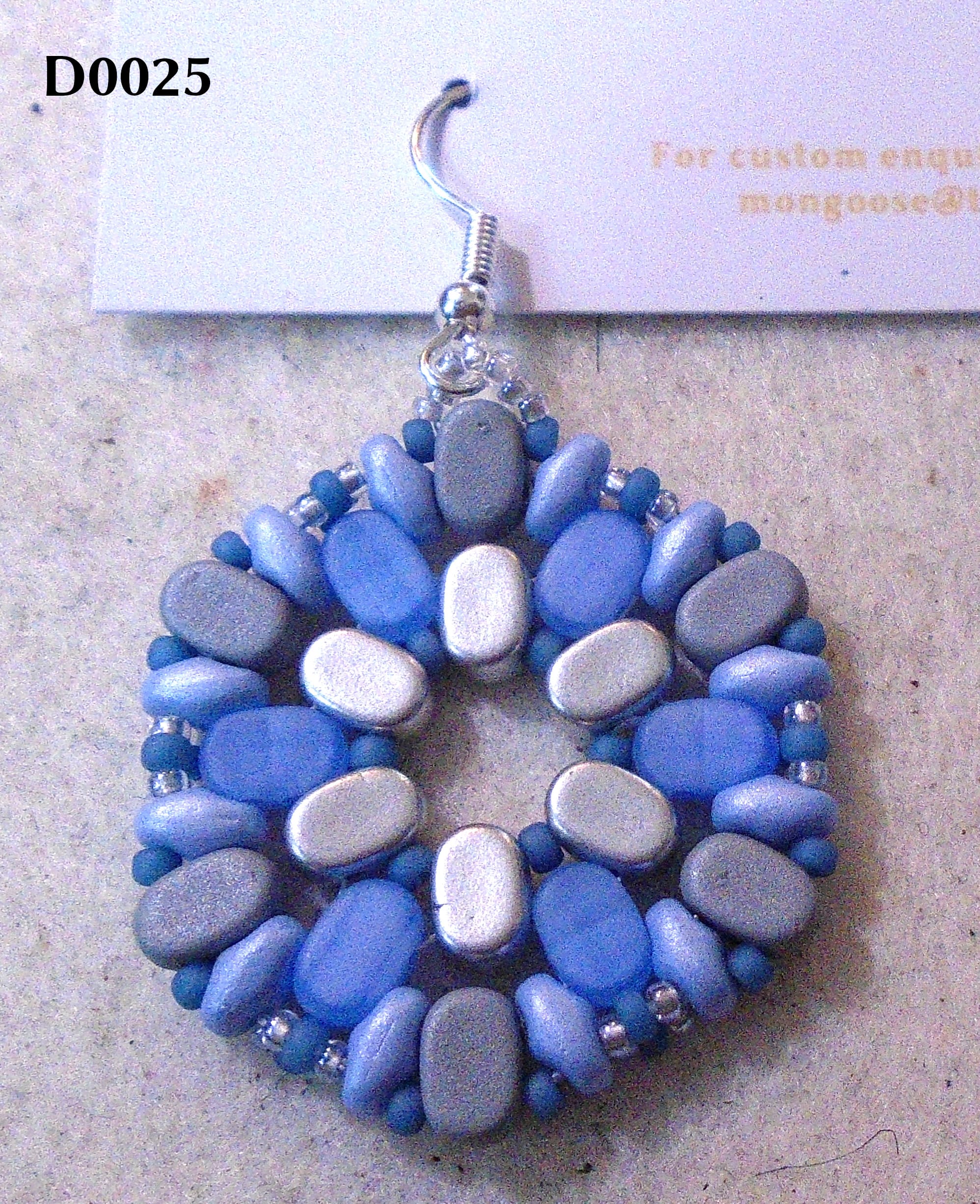 Hexagonal earring with silver, light blue, and mid grey oval Lipsi beads; light blue SuperDuos; blue and silver seeds.