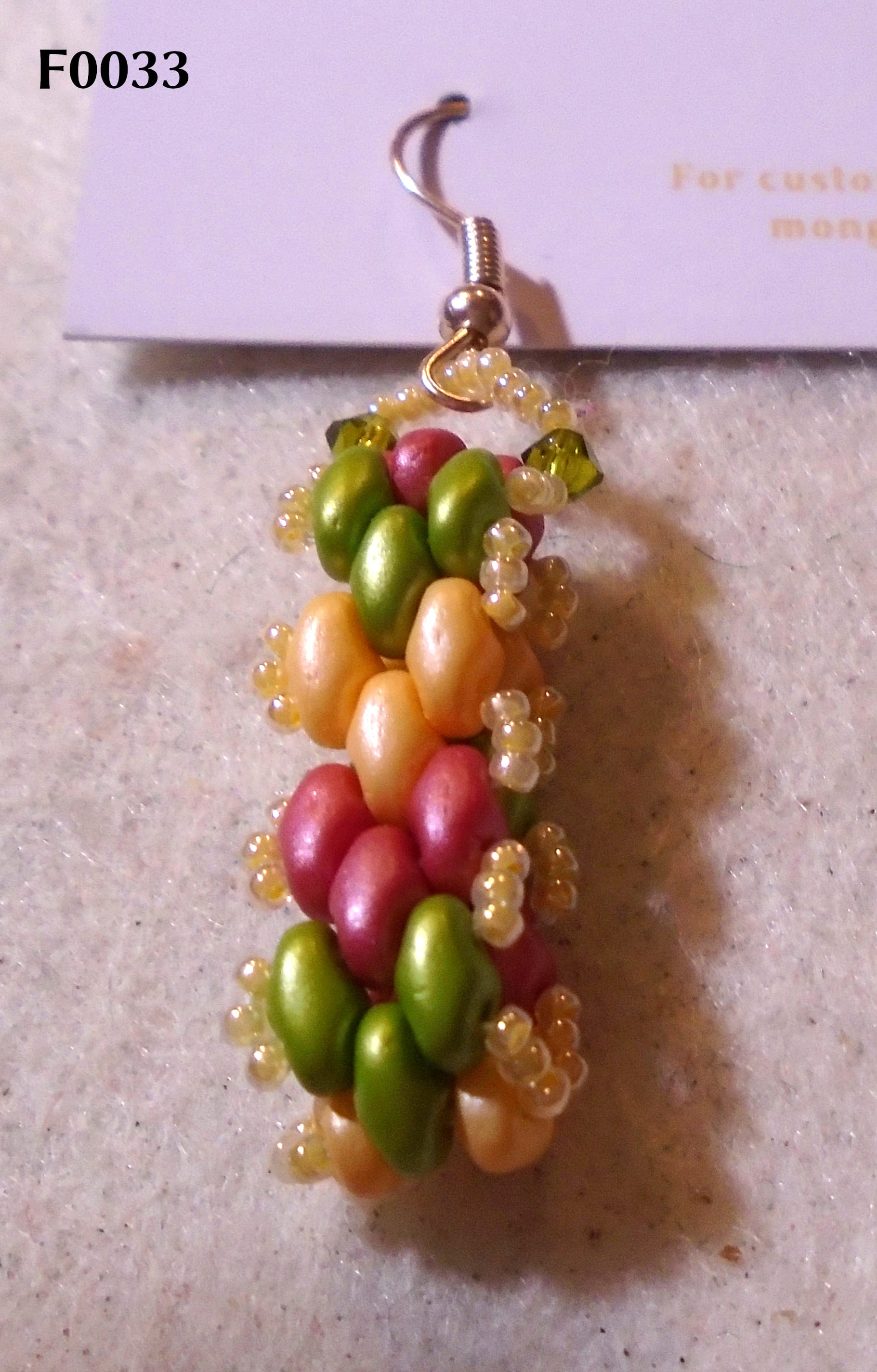 Brickwork hoop dangle earrings with chevrons in muted shades of red, green, and yellow-orange.