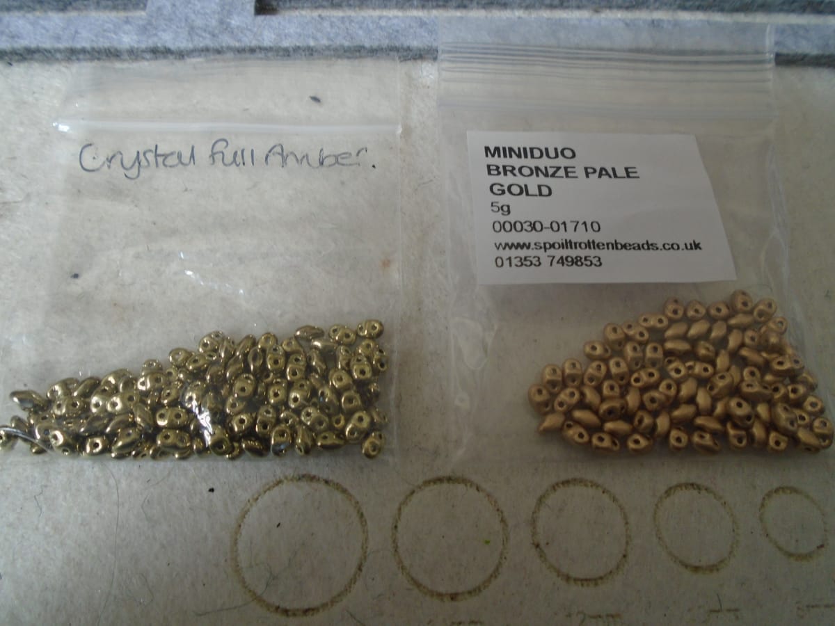 Two bags of MiniDuo beads. L, Crystal Full Amber (shiny off-gold); R, Bronze Pale Gold (less shiny but more gold).