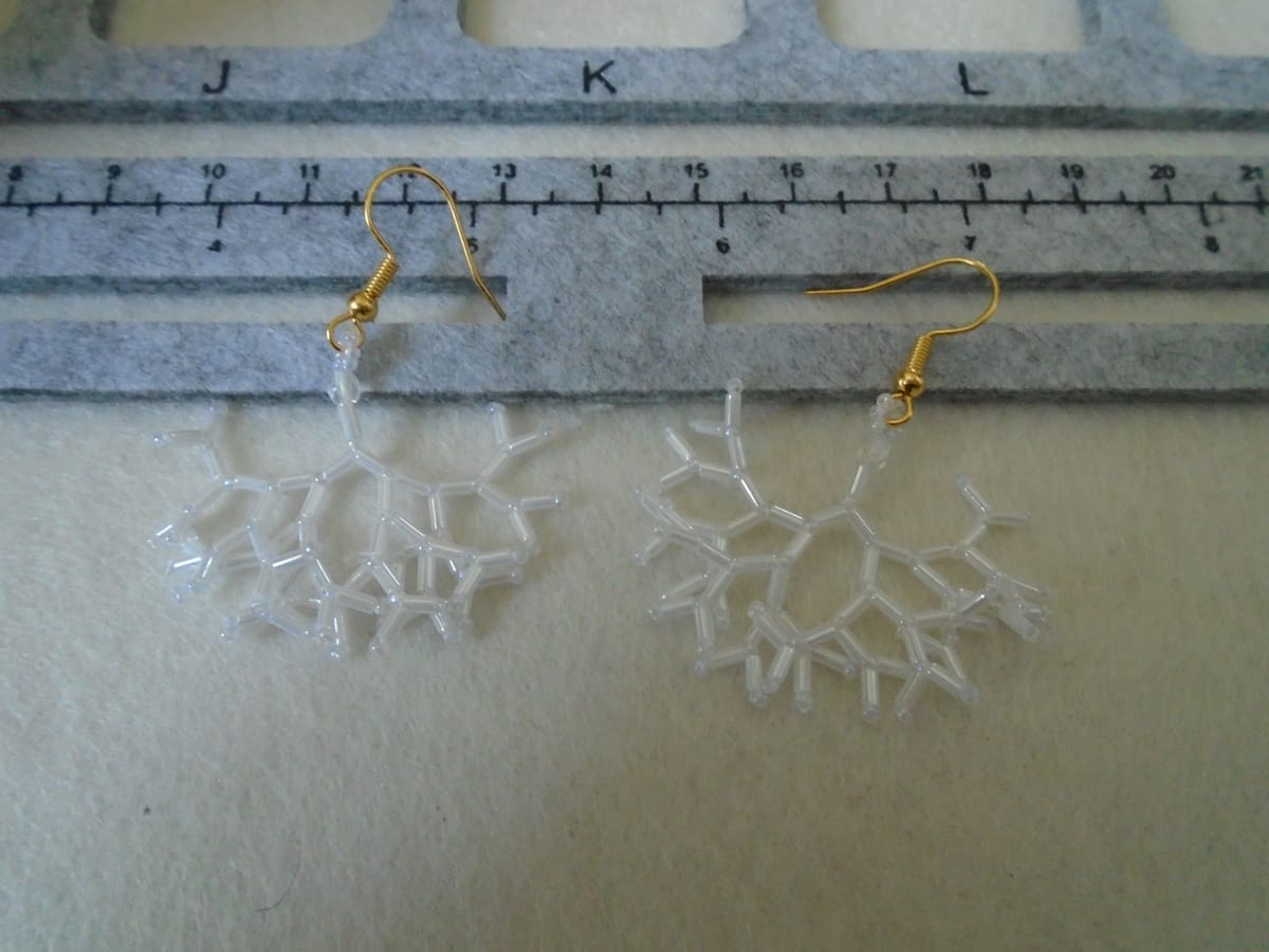 Unusual white drop earrings made from (mostly) bugle beads. Like a cross between a snowflake and a tree root.