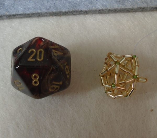 Left: d20 die.  Right: attempted, and very wonky, icosahedron (technically the same shape) made from beads.