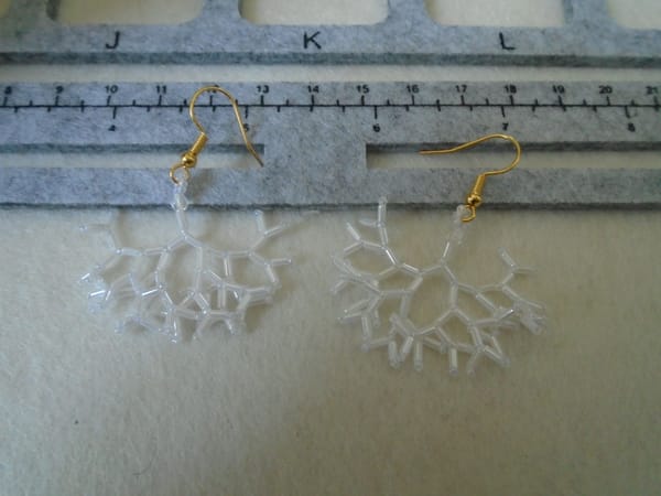 Unusual white drop earrings made from (mostly) bugle beads. Like a cross between a snowflake and a tree root.