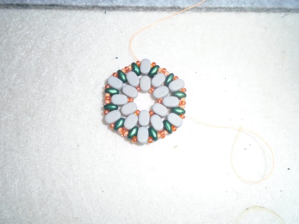 Not an earring, just the beady bit.  It's made mostly from grey oval beads, with a few others in green and orange.