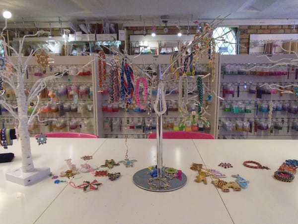 A table with two display trees hung with bead jewellery and ornaments.  There are more lying on the table.