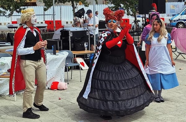 The King and Queen of Hearts.  Alice and the Cheshire Cat look on in the background.