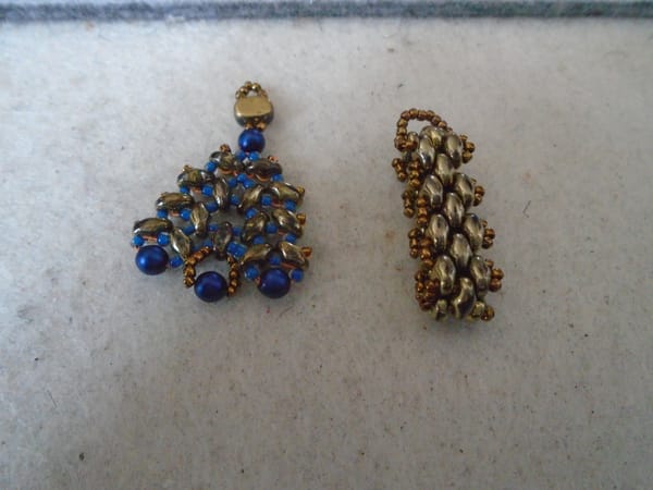 Left: a roughly triangular design in blue and bronze-gold.  Right: a simple brickwork loop in bronze-gold.