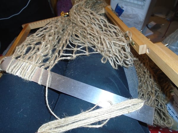 The net is anchored at the top of the frame a few meshes off the working line.  There are a few loops on the mesh stick.