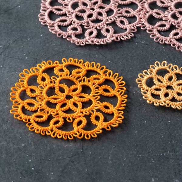 Circular tatted motifs in different sizes and colours, all with a lot of picots around the edges.